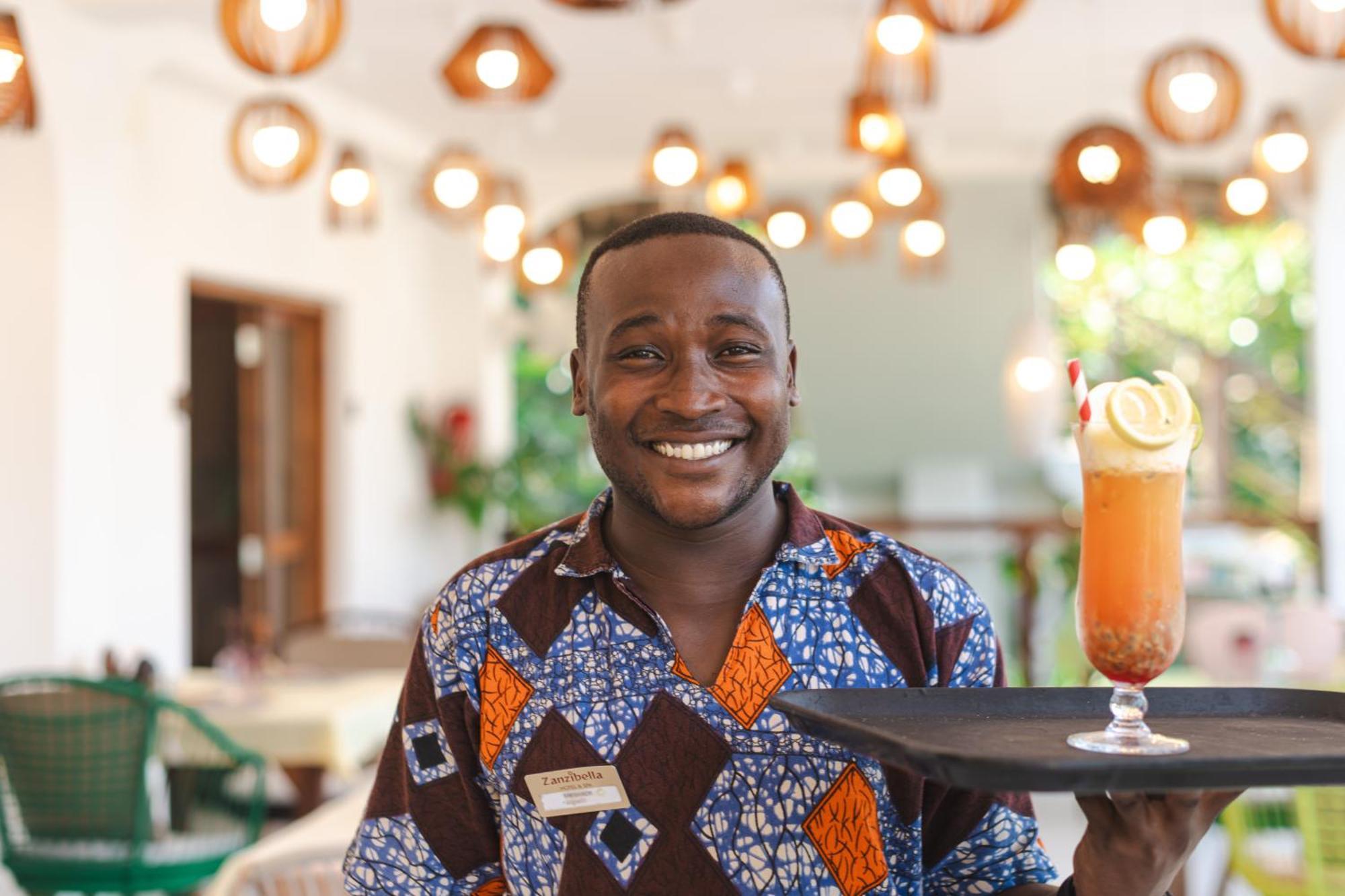 Zanzibella Hotel & Spa Kiwengwa  Bagian luar foto A waiter at the Serena Hotel in Kampala, Uganda